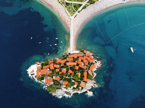 Aerophotography. Aerial view of Sveti Stefan island in a beautiful summer day, Montenegro from flying drone. Panoramic above view of Saint Stephen luxury resort. Tourism and leisure concept