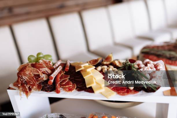 Mix Of Different Snacks And Appetizers Tapas Bar Ham Sausage Cheese Jamon Salami Grape Figs And Rosemary On White Plate On Corporate Christmas Birthday Party Event Or Wedding Celebration Stock Photo - Download Image Now