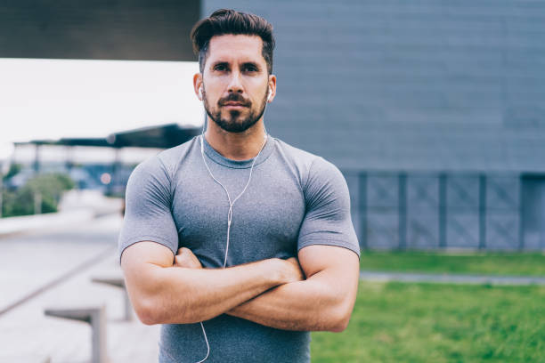 istock Confident jogger with earphones standing in street 1461200007