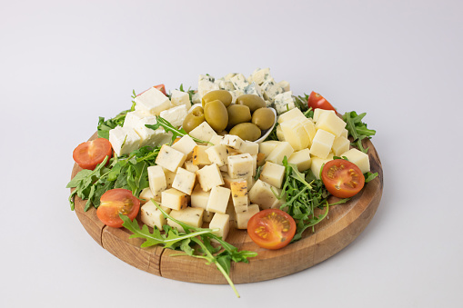 Close up of wooden plate with different types of cheese.
