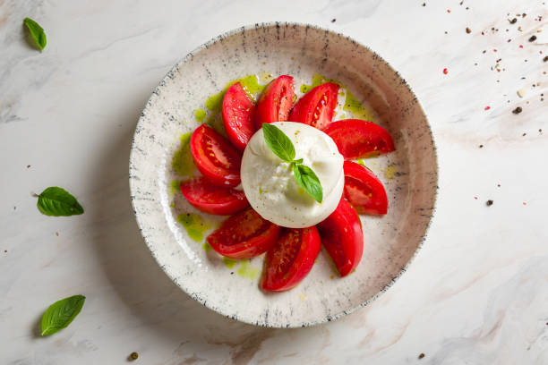 salada com queijo buratta, manjericão e tomates na tigela na vista do tampo da mesa de mármore branco - buratta - fotografias e filmes do acervo