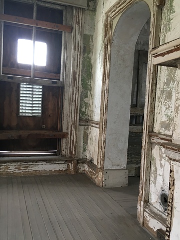 An archway with peeling and dingy paint- abandoned hospital on Ellis Island, New Jersey