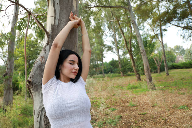 istock Beautiful young woman arms raised stretching in forest 1461217304