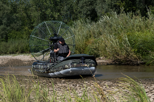 a chigh-speed riding in an airboat on the river on a summer day with splashes and waves