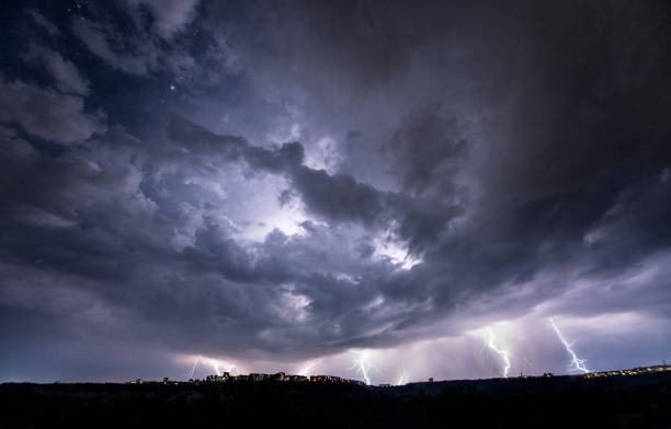 istock Beautiful thunderstorm with clouds and lightning over the night city 1461220709