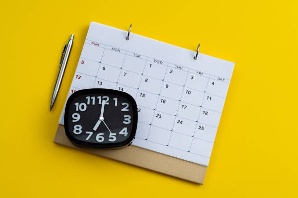 istock Calendar and alarm clock on yellow background 1461222078