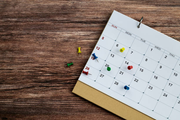Colored pins on the calendar stock photo