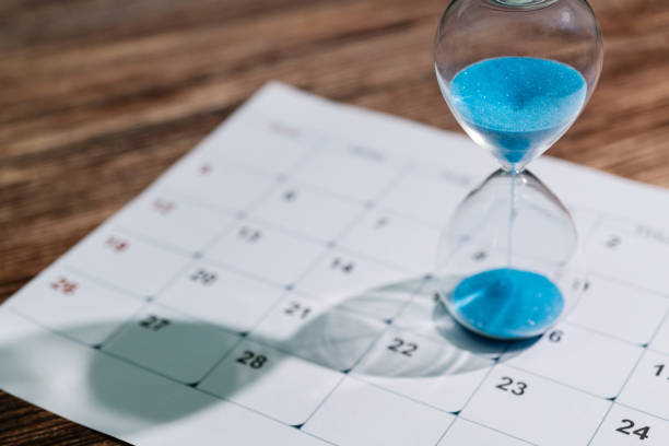 Calendar and hourglass on the table stock photo