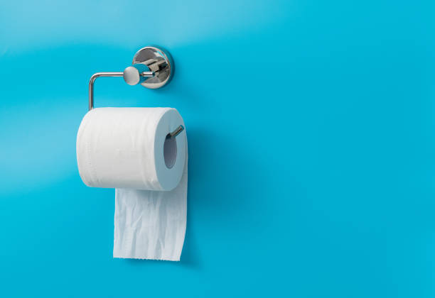 Toilet paper hanging on blue background.