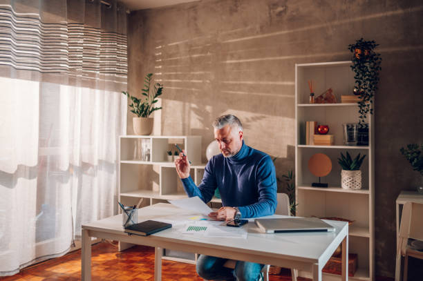 istock Gray haired middle aged man working in a home office 1461227284