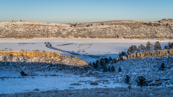 winter scenery in foothills of Rocky Mountains in northern Colorado with frozen Horsetooth Reservoir