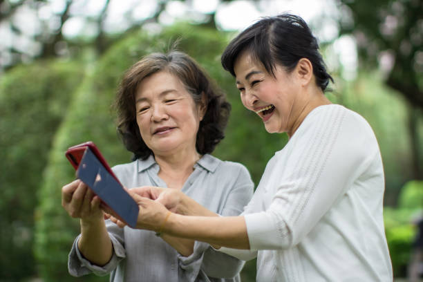 istock Two mature woman reading text messages together 1461230040