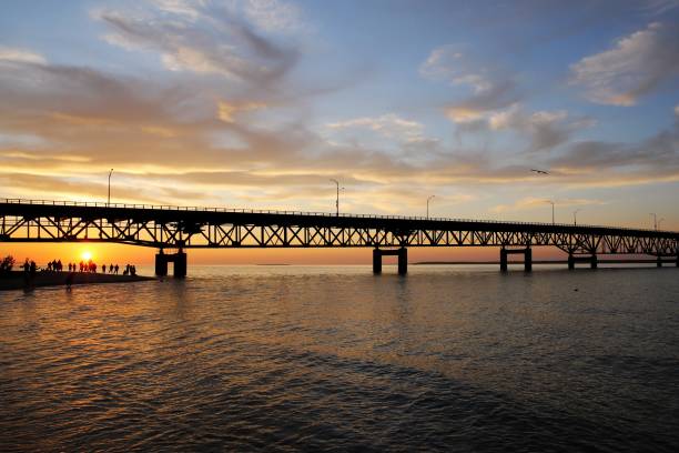 turisti che godono di un bellissimo tramonto sul lago michigan sotto mackinac bridge, mackinaw city, michigan, usa - straits of mackinac foto e immagini stock