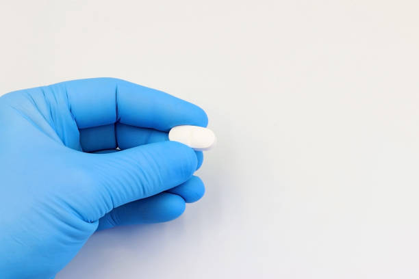 istock Doctor's hand with a capsule, antibiotic, or medicine pill 1461250283