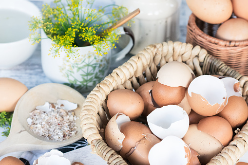 Brown and white eggshells placed in basket in home kitchen on table, eggshells stored for making natural fertilizers for growing vegetables, sustainability concept