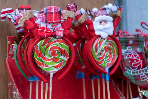 red and green lollipop candies in the store. Confectionery candy shop lollipops  in the plastic bag with santa claus and snowman decorations.
