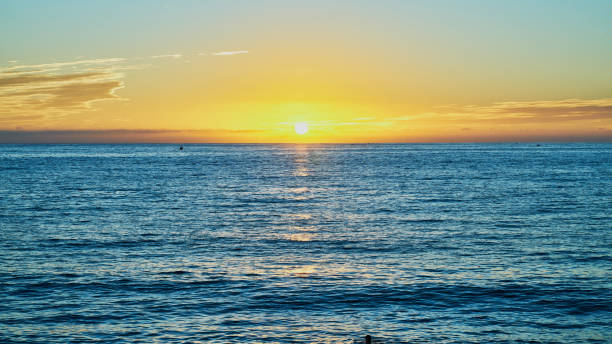 istock sunset on the beach and the sun is setting on the horizon 1461259285