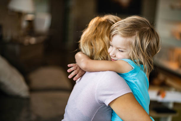 istock Smiling little boy embracing his single mother at home. 1461259804
