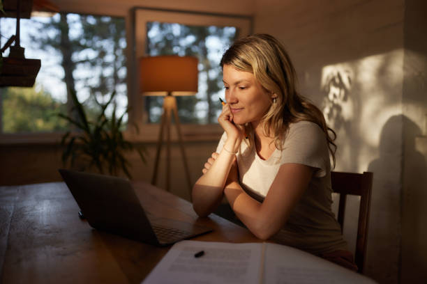 istock Smiling woman working on laptop at her home office. 1461260714