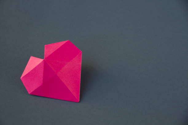 istock pink paper heart origami isolated on a grey background 1461260848