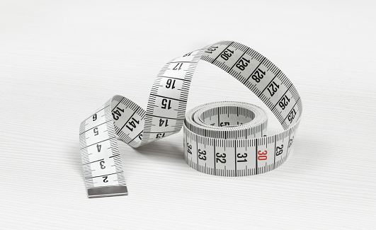 Measuring tape isolated on a white wooden background