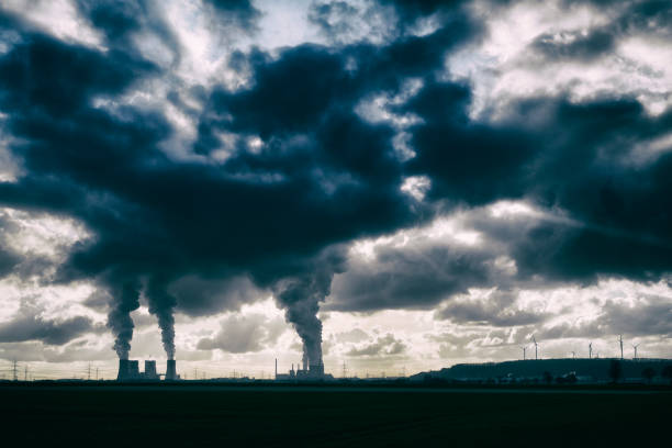 istock Two coal fired power plants with pollution and wind turbines 1461263203