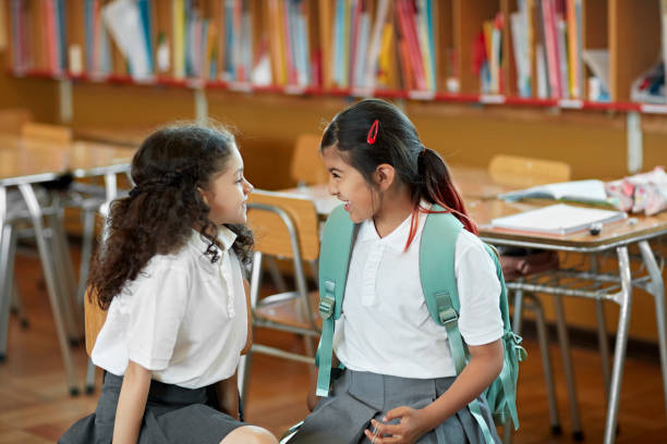 istock Hispanic schoolgirls face to face and grinning 1461264950