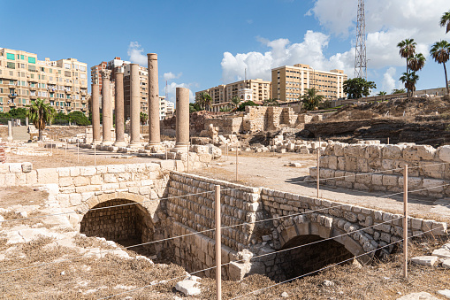 Ancient Roman artifacts at the excavations against the blue sky in the city Alexandria. Egypt. Attractions.