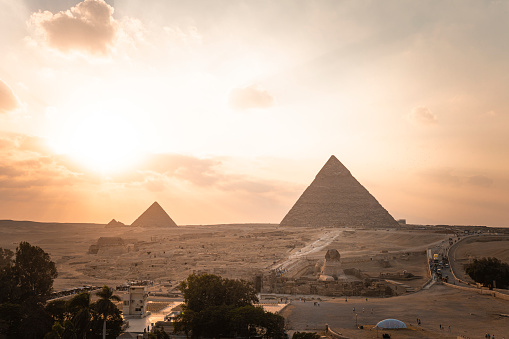 Archaeological complex of the Great Egyptian Pyramids is located on the Giza plateau. second pyramid of Chephren khefren in the night light at sunset. sun sets behind the pyramid. sphinx at sunset