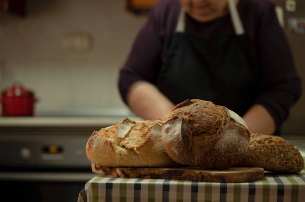 istock Close up of breads in kitchen with a old lady working in background 1461271433