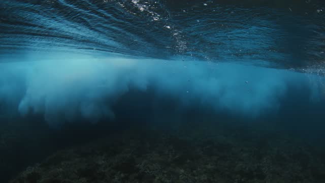 Wave crashing in ocean. Underwater view of surfing barrel wave