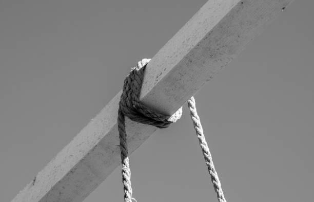 A close-up of a rope wrapped around a beam in black and white