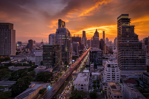 Beautiful, panoramic sunset view of the skyline of Bangkok. Lumphini, with street traffic and golden colors