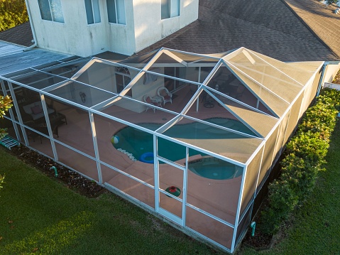 An aerial view of pool screen enclosure surrounded by trees