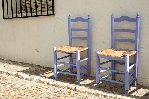 A pair of traditional Mediterranean wooden chairs on the streets of Altea, Alicante, Spain
