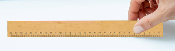 istock Hand holding a wooden ruler isolated on the white background 1461283095