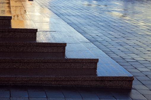 wet red granite stairs and city pavement pattern -  textured background with sunlight and reflections, city lines with sunlight