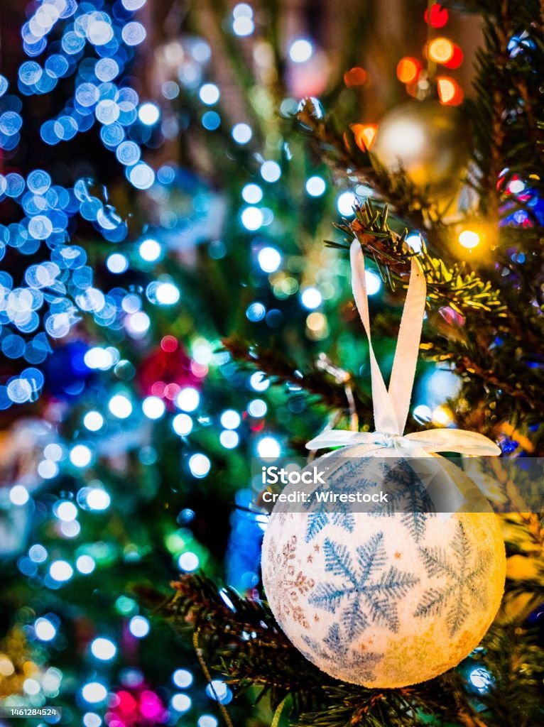 Closeup of Christmas tree hanging bauble with colorful lights blurred background A closeup of Christmas tree hanging bauble with colorful lights blurred background Bicester Stock Photo