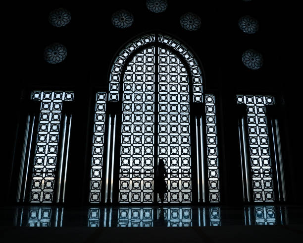 Silhouette of the woman against the windows inside the Hassan II Mosque in Casablanca, Morocco. The silhouette of the woman against the windows inside the Hassan II Mosque in Casablanca, Morocco. casablanca stock pictures, royalty-free photos & images
