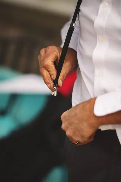 A man fixing a suspender on pants