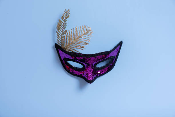 istock Festive face masks for carnival or masquerade celebration on colored banner background flat lay, top view 1461287822