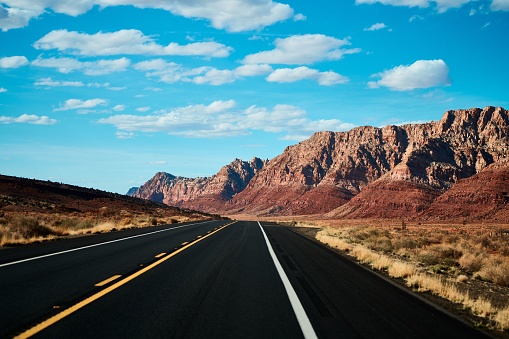 A straight desert road under blue sky on a sunny day in Arizona, United States