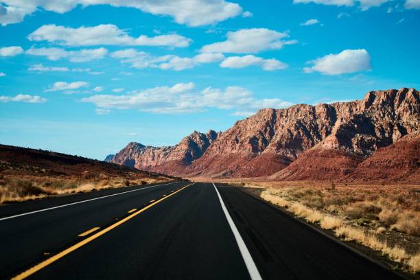 прямая пустынная дорога под голубым небом в солнечный день в аризоне, сша - mountain states стоковые фото и изображения