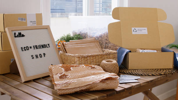 Net zero waste go green SME use eco friendly care sign plastic free symbol packaging carton box wrap paper in small shop retail store. Chva dried water hyacinth on desk reuse packing parcel supplies. cero residuos netos ir verde pyme utilizar signo de cuidado ecológico símbolo de plástico libre embalaje caja de cartón papel de envolver en una pequeña tienda minorista. jacinto de agua seca chva en el escritorio reutilizar los suministros de paquete