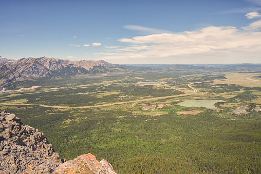 Landscape of the Alberta Prairie's from the top of Yates Mountain with a Rocky cliff in the foreground, Canada  Blue cloudy sky.