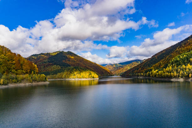 istock Beautiful view of a lake surrounded by mountains under a cloudy sky 1461298352