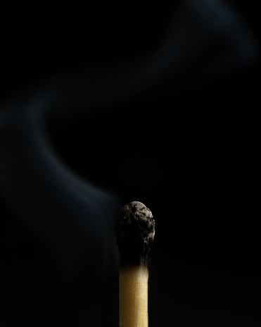 A closeup shot of a burnt match on a black background