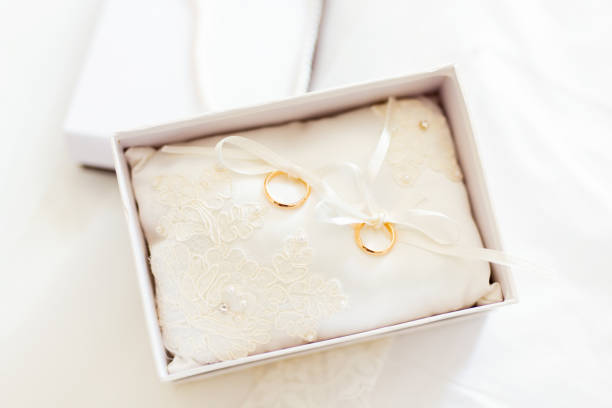 istock Two golden wedding rings on a white pillow 1461300559