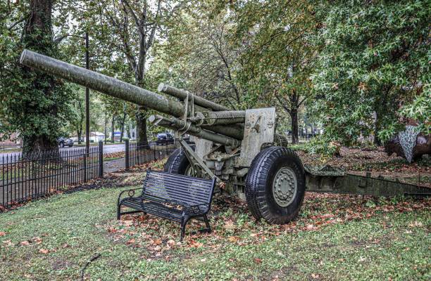 istock Historical cannon displayed in a green park next to a bench 1461300973