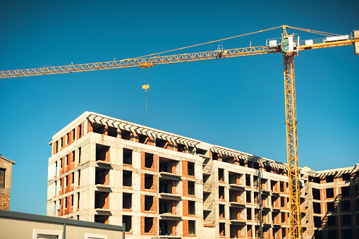 Construction site with cranes and building with blue sky background